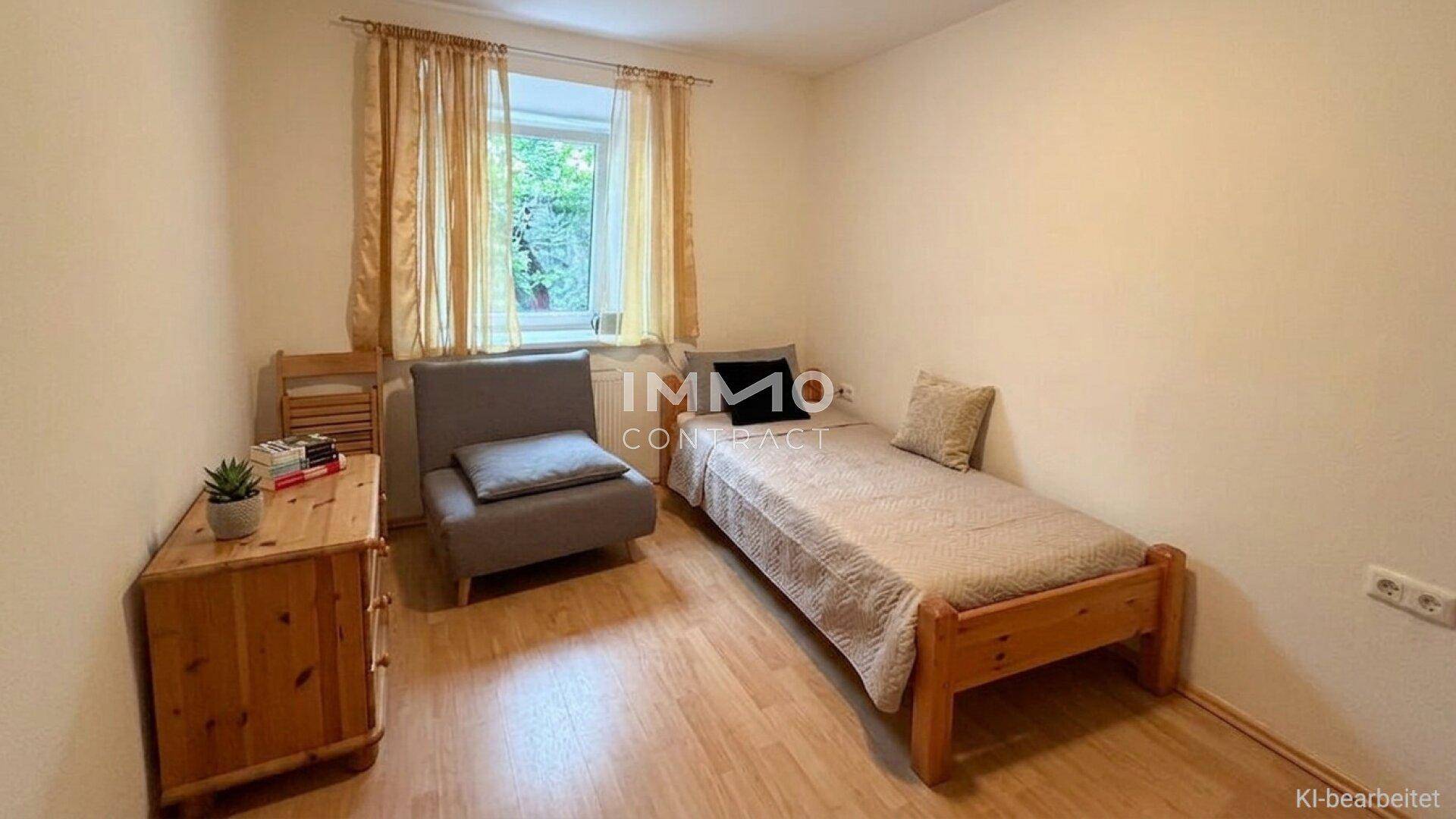 Gemütliches Schlafzimmer mit Einzelbett, Holzboden und einem Fenster mit Blick ins Grüne.