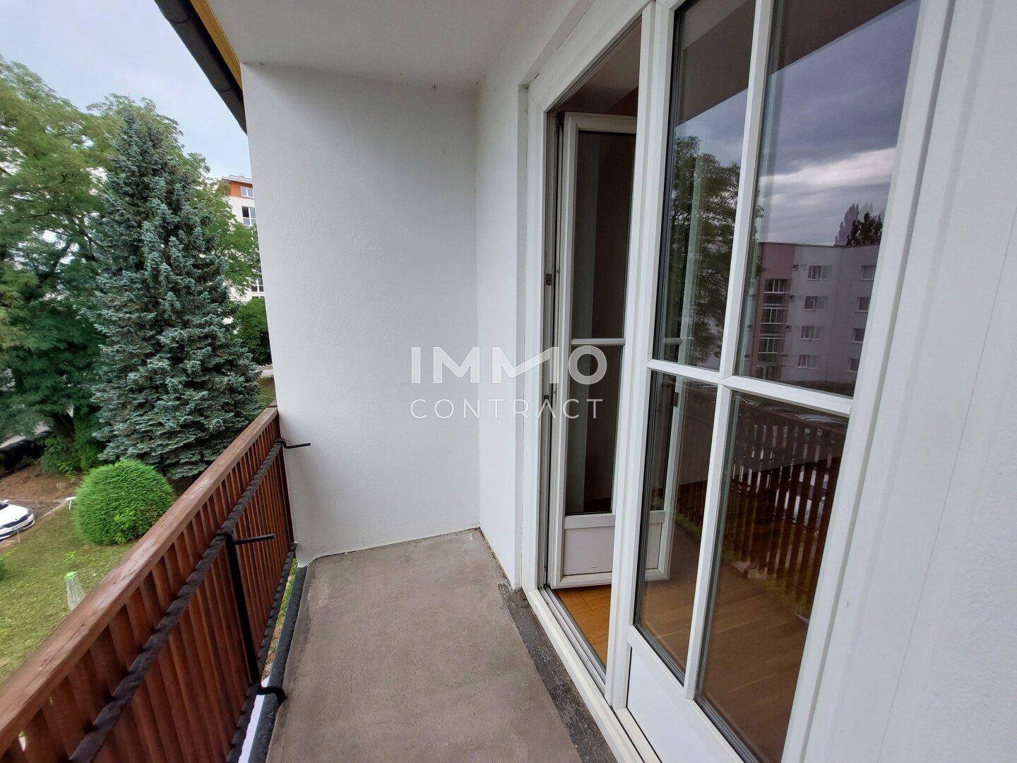 Kleiner Balkon mit Holzbalkon und Blick ins Grüne.