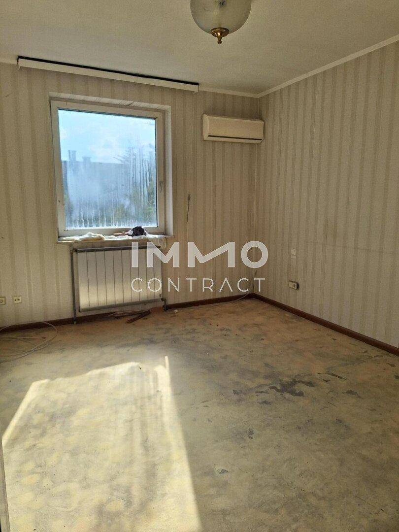 Helles Schlafzimmer mit Heizkörper und Fenster, bietet Potenzial für eine individuelle Gestaltung.