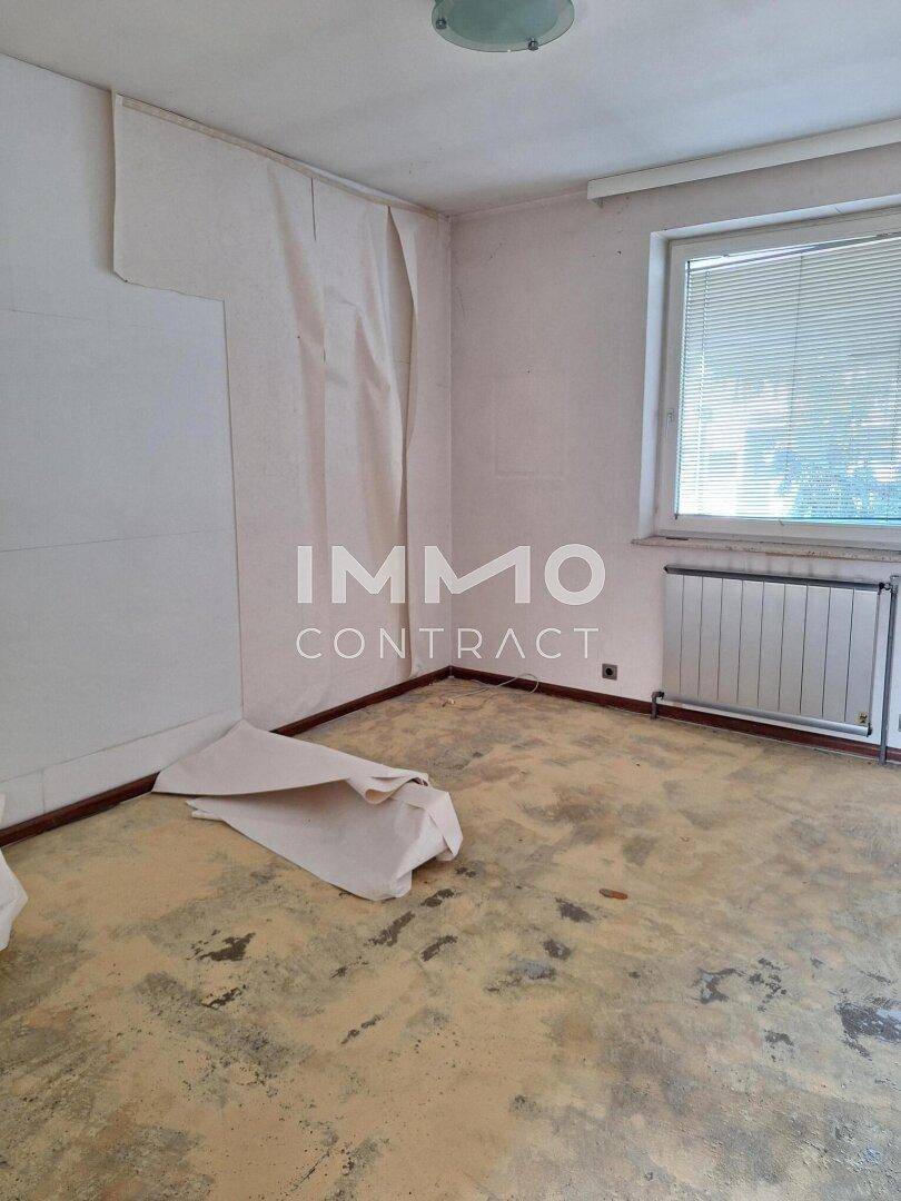 Schlafzimmer in Renovierung mit abgelöster Tapete und Fenster, bereit für neue Oberflächen.
