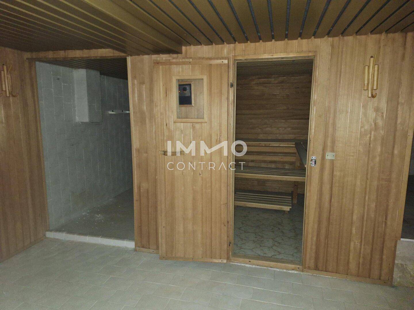 Holzvertäfelte Sauna mit Bänken, Teil eines Wellnessbereichs im Untergeschoss des Hauses.