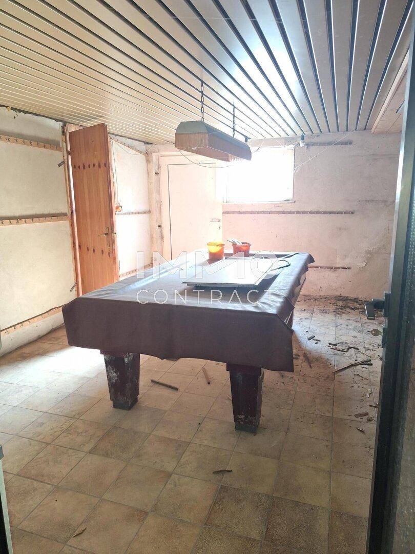 Spielzimmer im Untergeschoss mit Billardtisch und Fenster, bietet Raum für Freizeitaktivitäten.