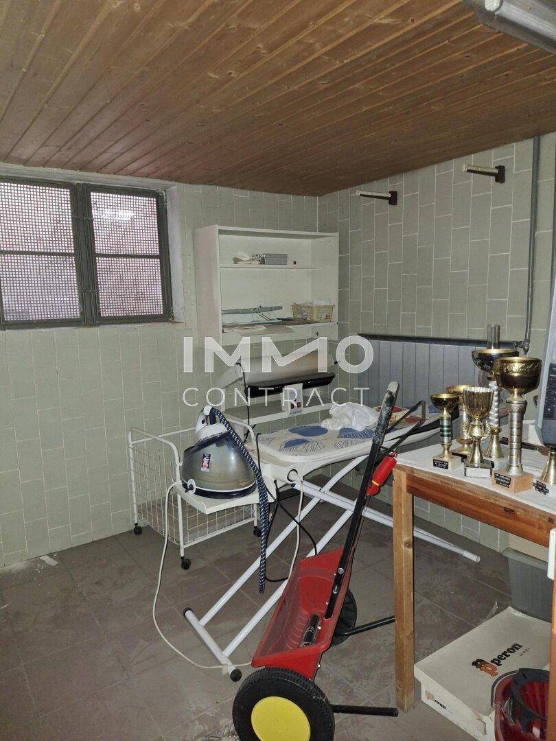 Funktionaler Hauswirtschaftsraum mit Fliesenwänden, Holzdecke und kleinem Fenster.