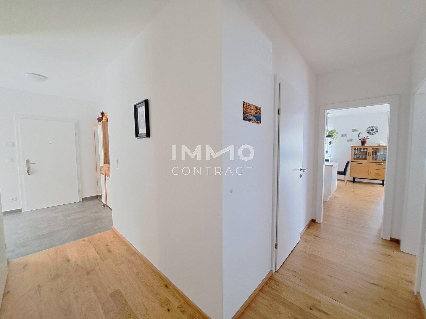 Heller Flur mit Holzboden und Zugang zu verschiedenen Räumen der Wohnung.