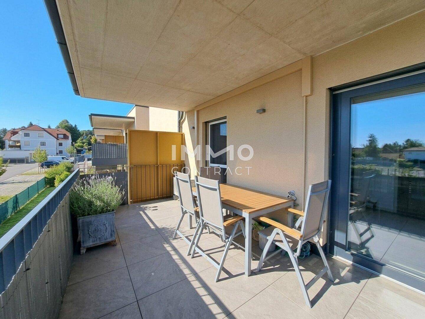 Geräumiger Balkon mit Esstisch, Stühlen und Blick auf die grüne Umgebung.