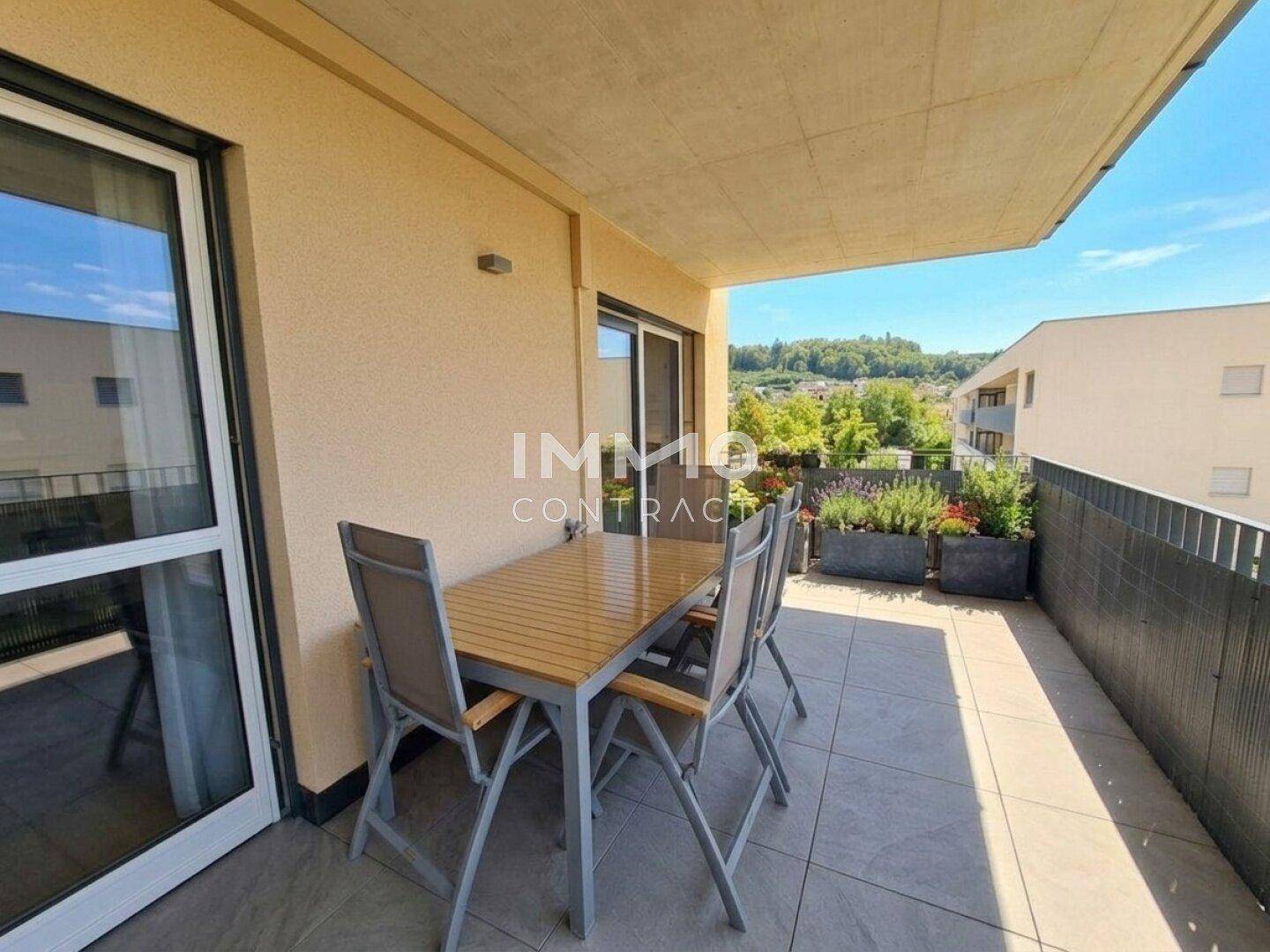 Sonniger Balkon mit Gartenmöbeln und weitem Blick über die Landschaft.