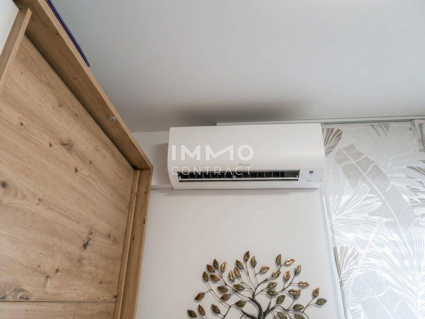 Detailaufnahme der Klimaanlage an der Wand in einem hellen Raum.
