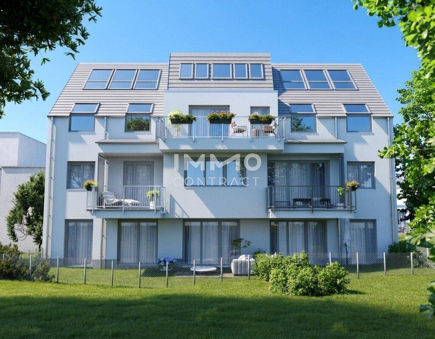 Modernes Mehrfamilienhaus mit mehreren Balkonen und Dachgauben, umgeben von Grünflächen.