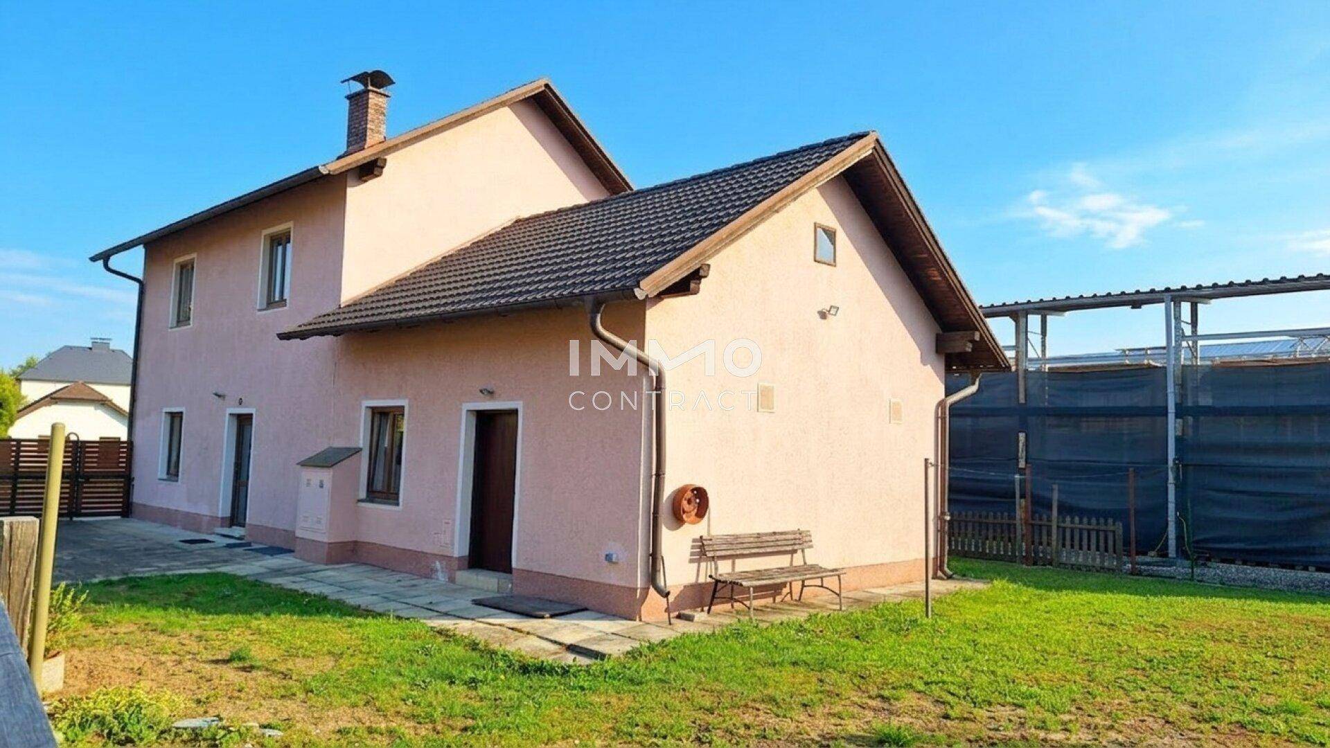 Rückseite des Hauses mit Garten, Sitzbank und Blick auf die Umgebung.