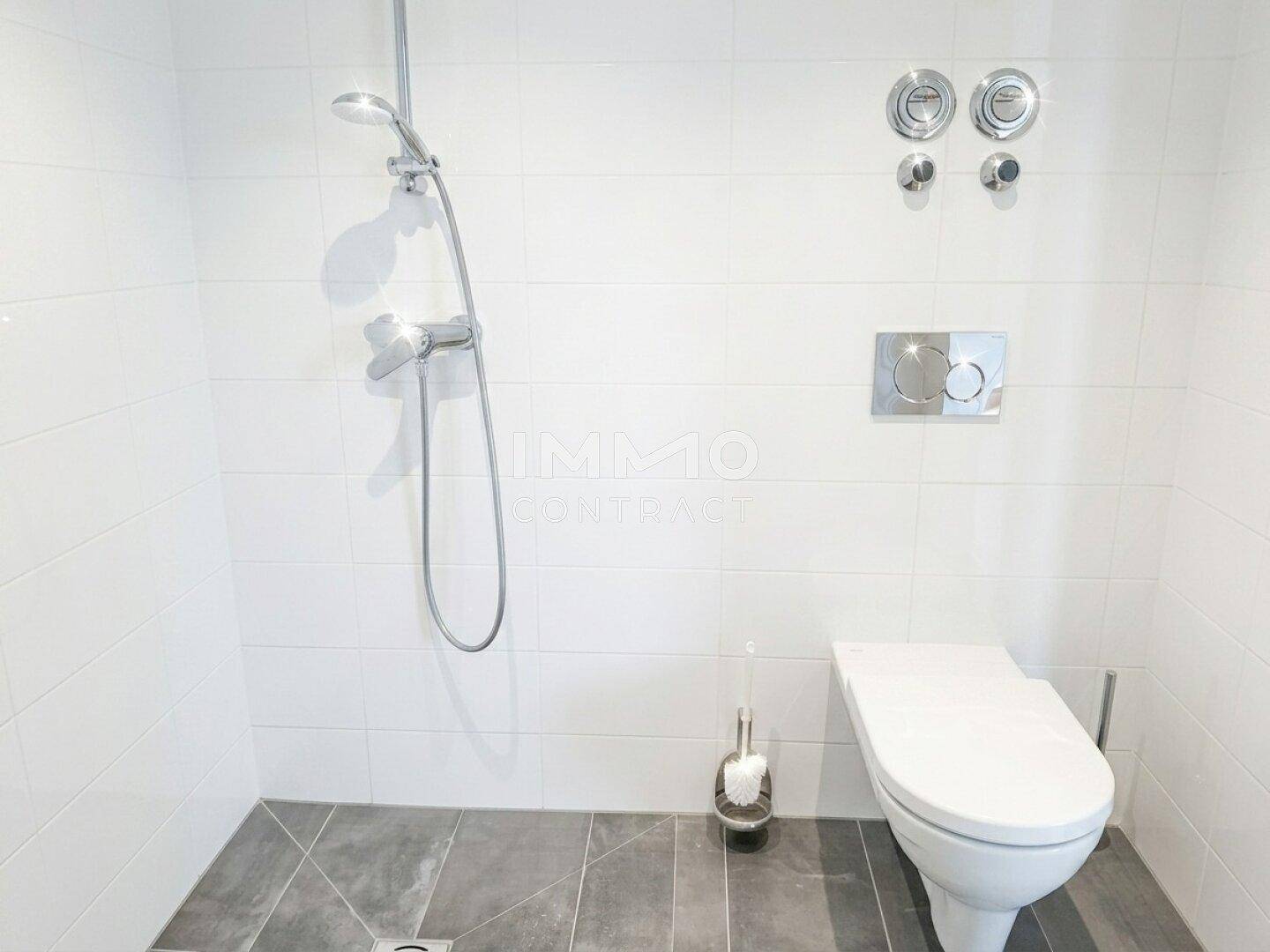 Helles Badezimmer mit Dusche, wandhängendem WC und modernen Fliesen.