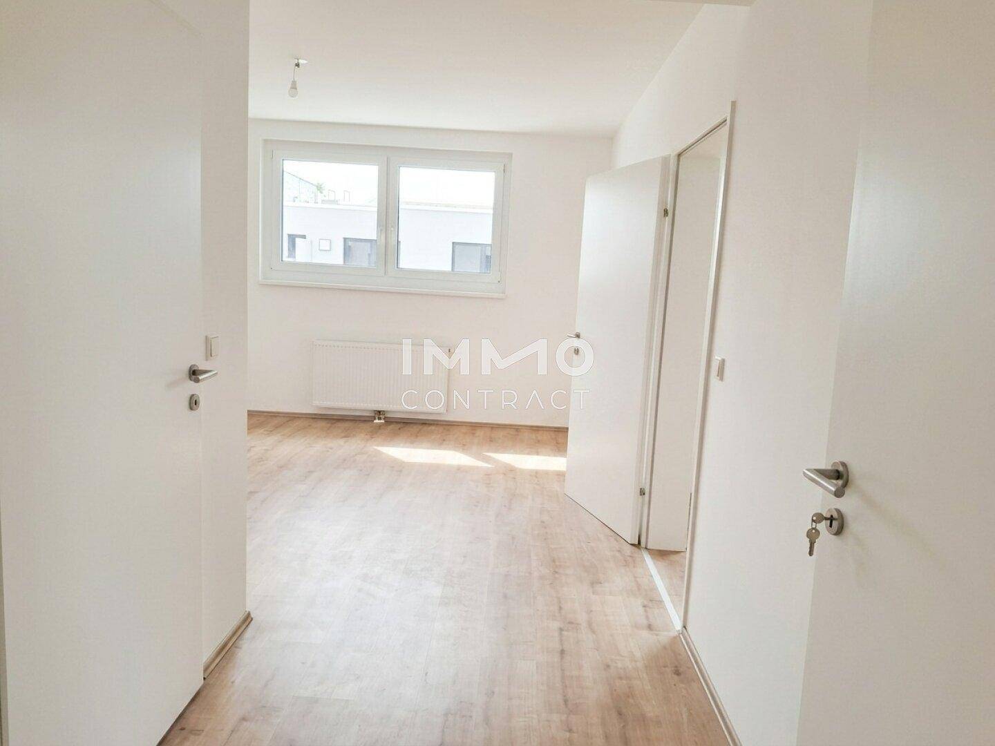 Unmöbliertes Schlafzimmer mit Laminatboden und großen Fenstern, bereit zur individuellen Gestaltung.