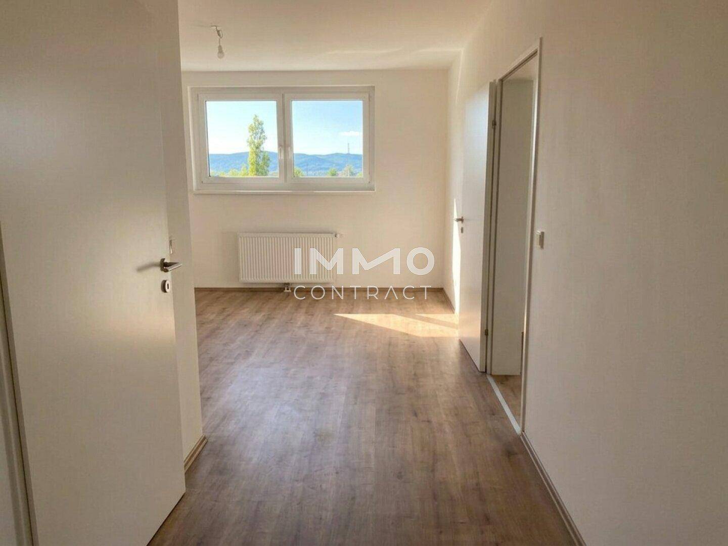 Heller Flur mit Laminatboden und Türen zu weiteren Zimmern.