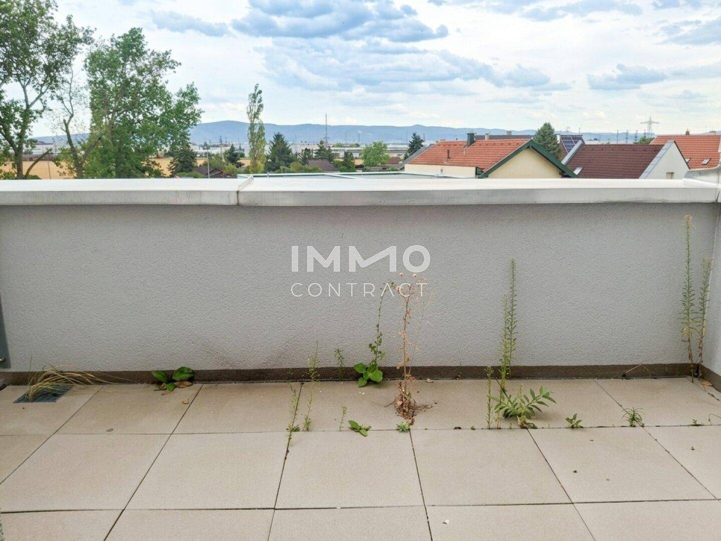 Terrasse mit Fliesenboden und Blick auf die Umgebung und Berge.