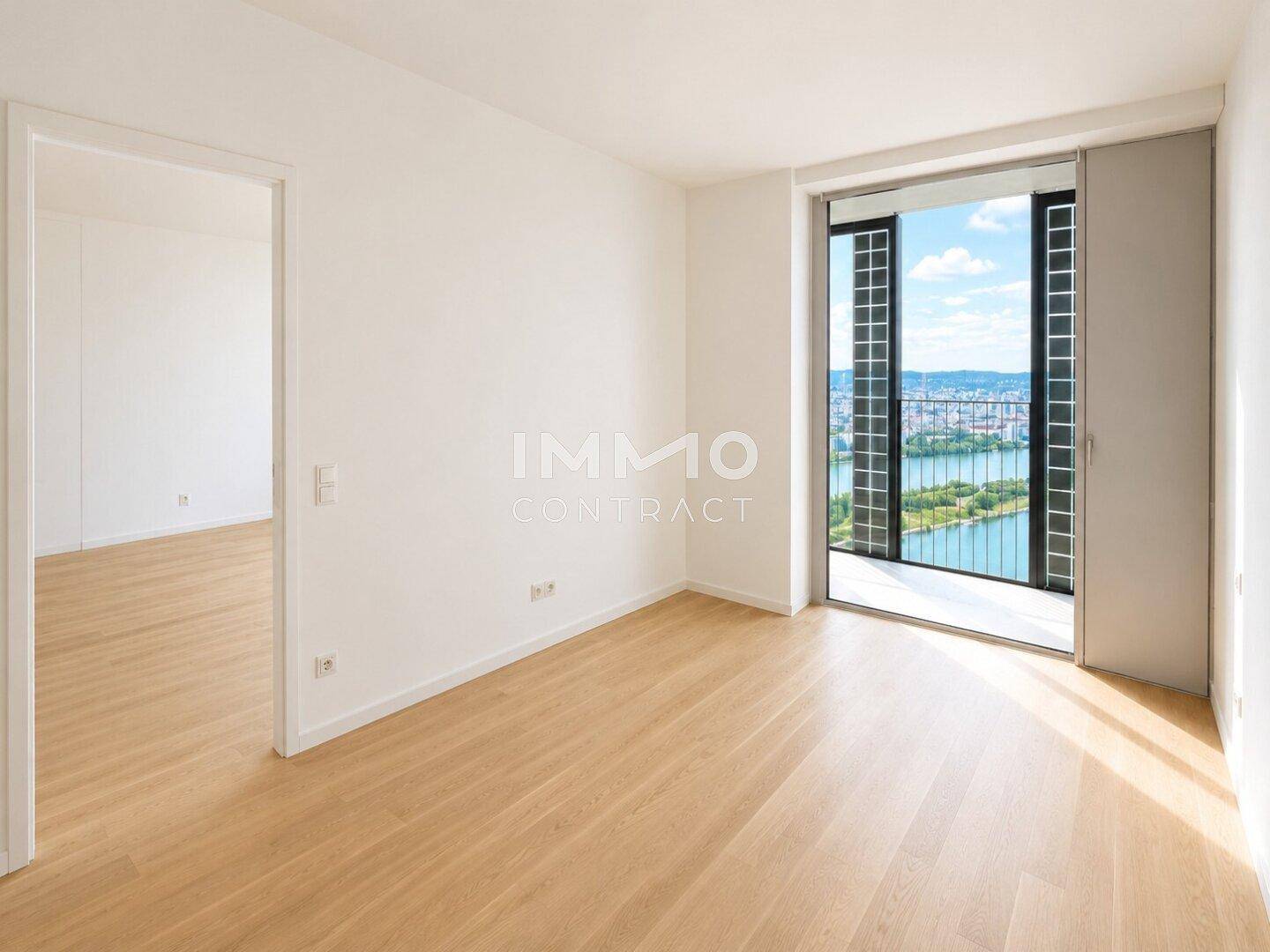 Helles Schlafzimmer mit Holzboden und Zugang zu einem Balkon mit Seeblick.
