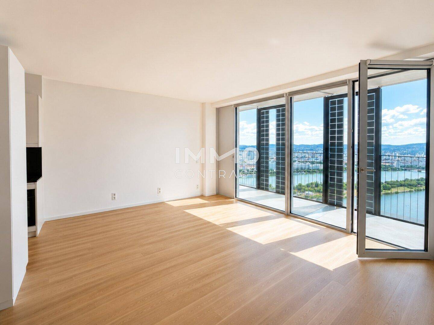 Lichtdurchfluteter Wohnbereich mit Holzboden und raumhohen Fenstern mit Panoramablick.