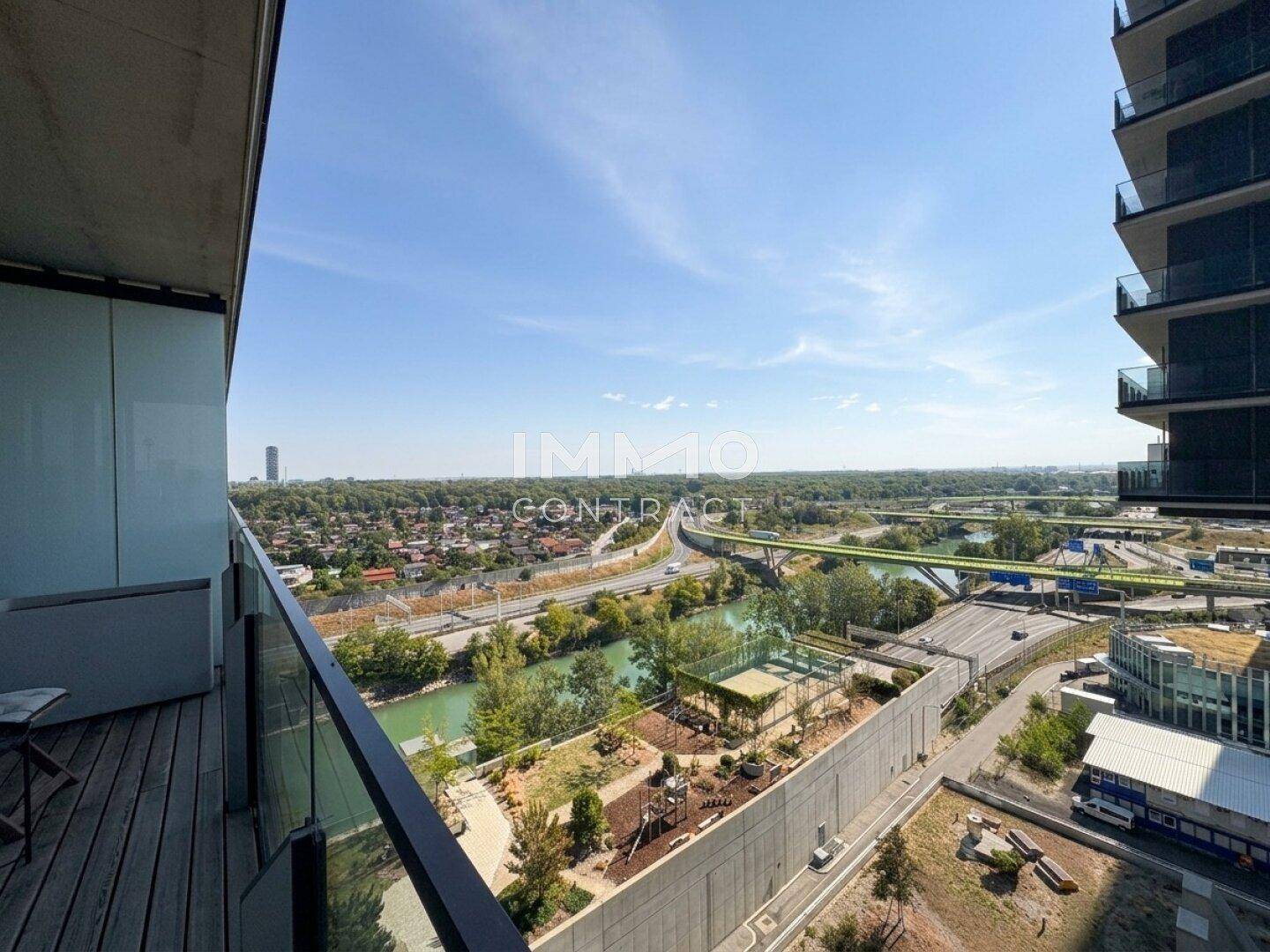 Balkon mit weitem Blick über die Stadt, Flusslandschaft und einen Spielplatz im Vordergrund.