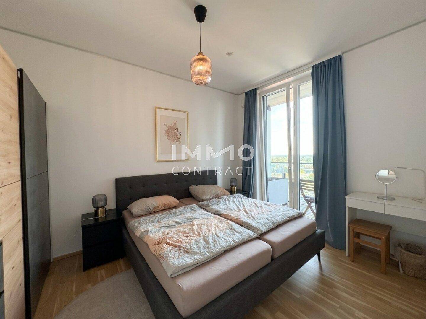 Helles Schlafzimmer mit Doppelbett, Kleiderschrank und direktem Zugang zum Balkon.