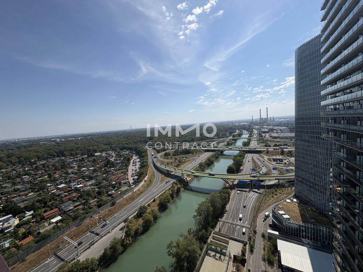 Panoramablick über die Stadt mit Fluss, Autobahn und modernen Hochhäusern.