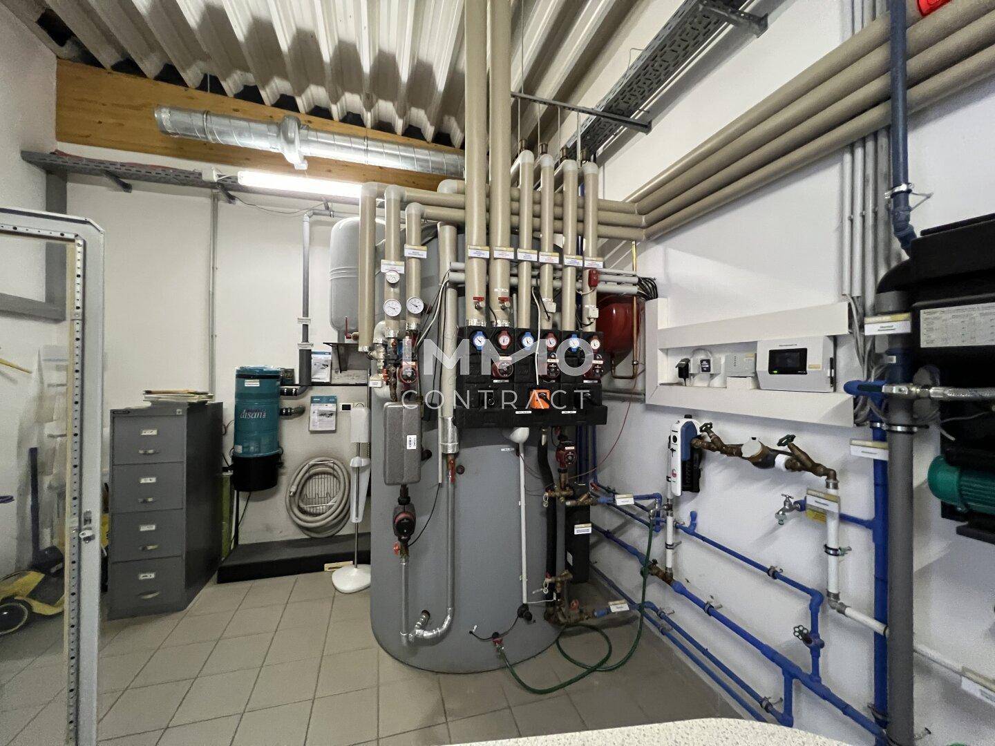 Technikraum mit Heizungsanlage, Rohrleitungen und Steuerungselementen für die Gebäudetechnik.