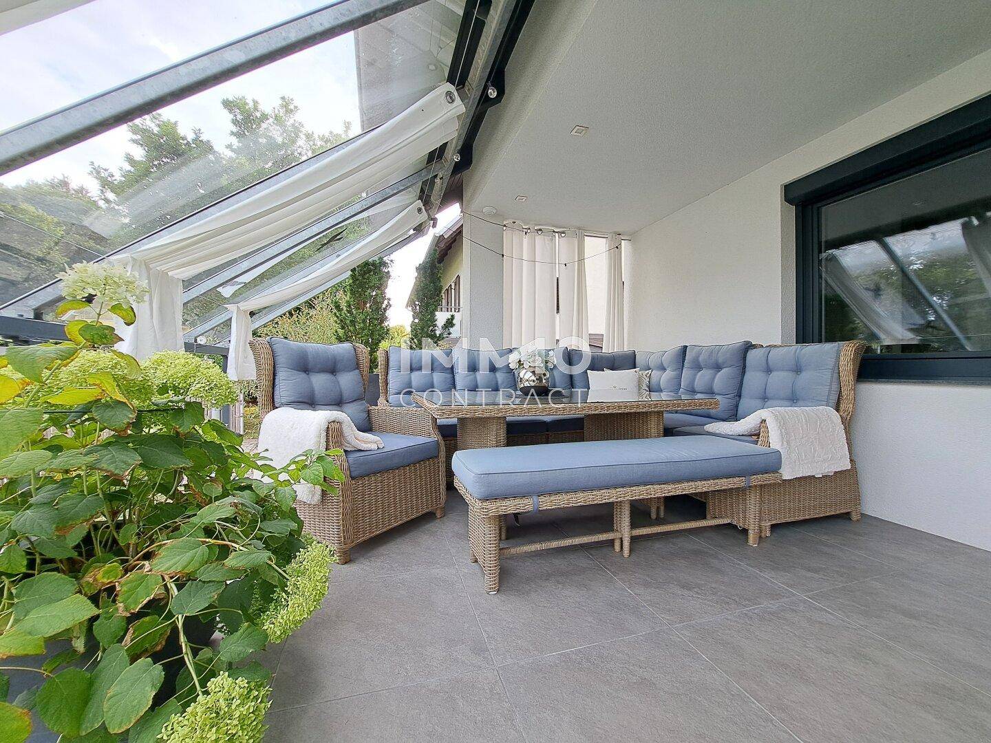 Gemütliche überdachte Terrasse mit bequemen Loungemöbeln und Blick ins Grüne.