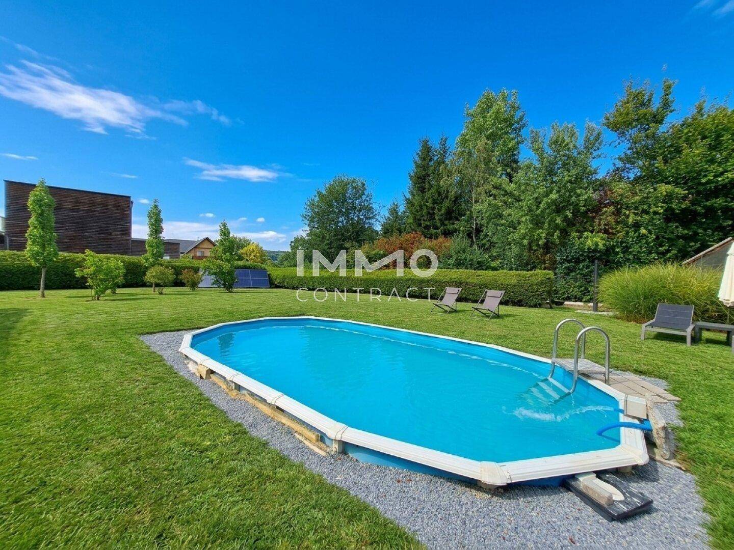 Großer Gartenbereich mit einem ovalen Aufstellpool und viel Grünfläche.