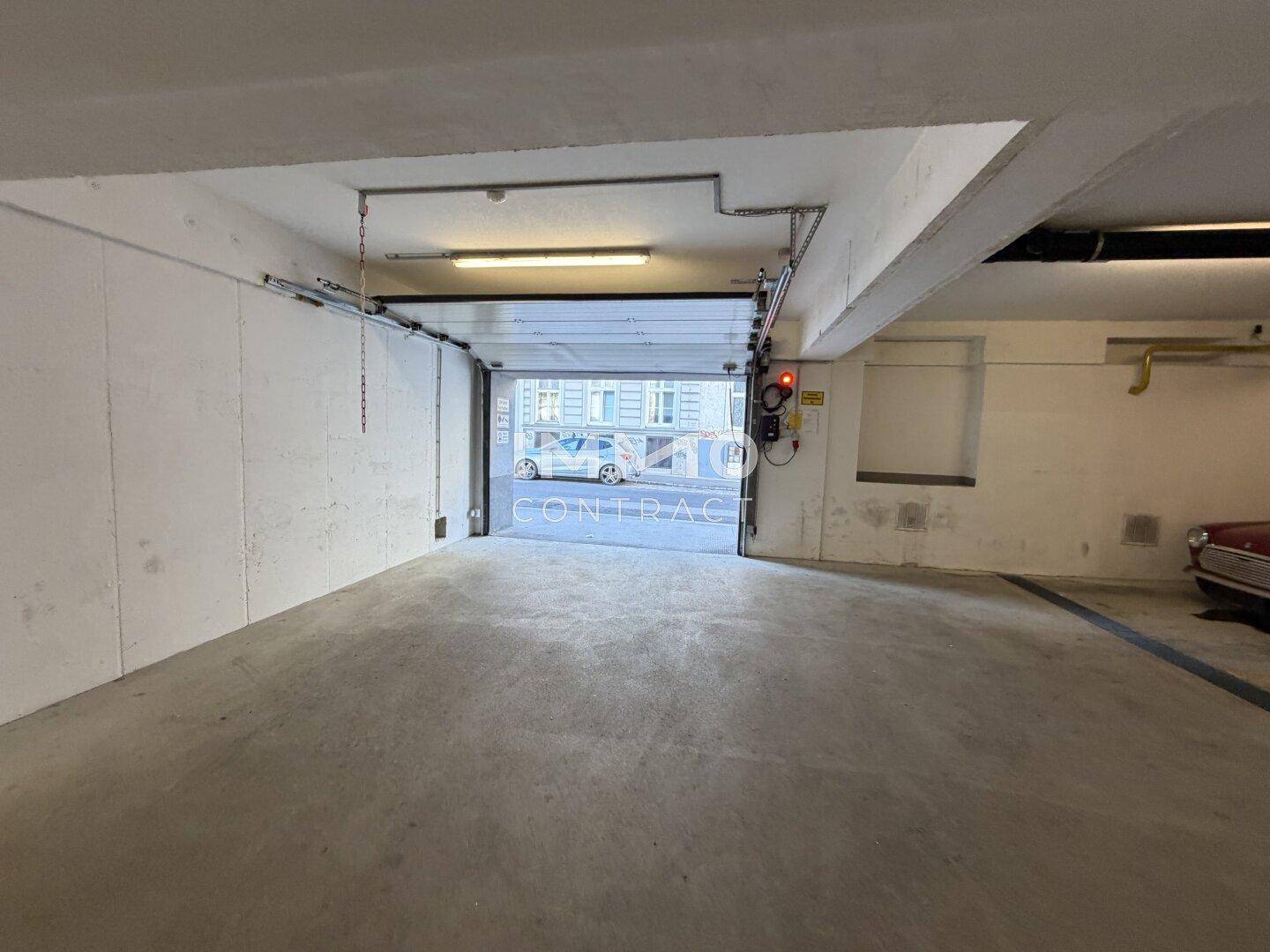 Ausfahrt einer Tiefgarage mit Blick auf die Straße und ein geparktes Auto im Freien.