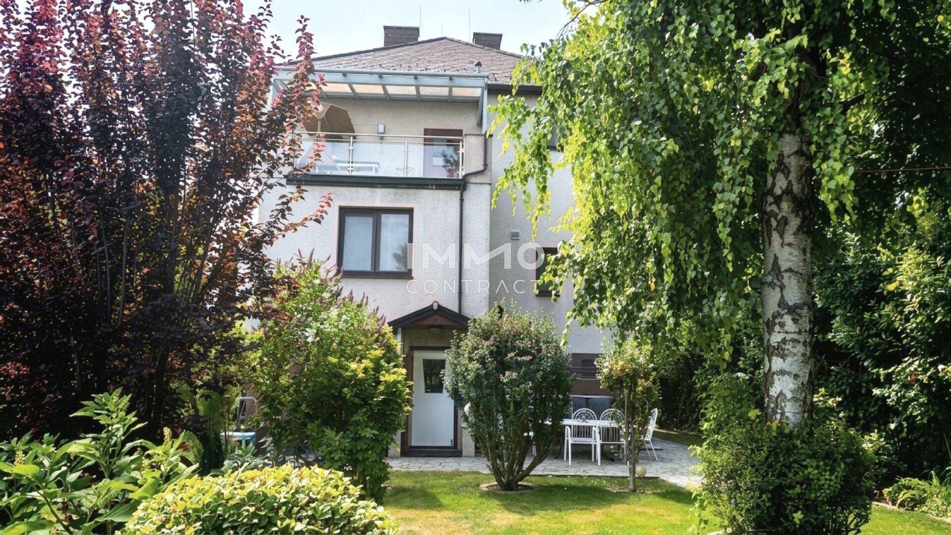 Rückseite des Hauses vom Garten aus gesehen, mit Balkon und Zugang zum Außenbereich.