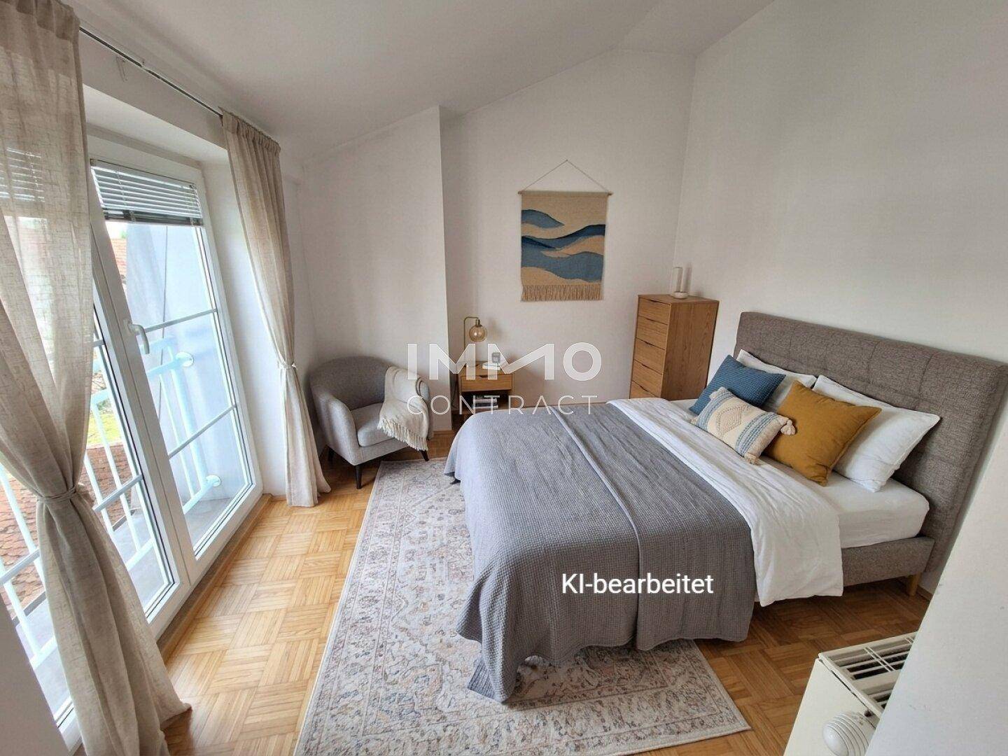 Helles Schlafzimmer mit Parkettboden, Bett und Zugang zu einem französischen Balkon.