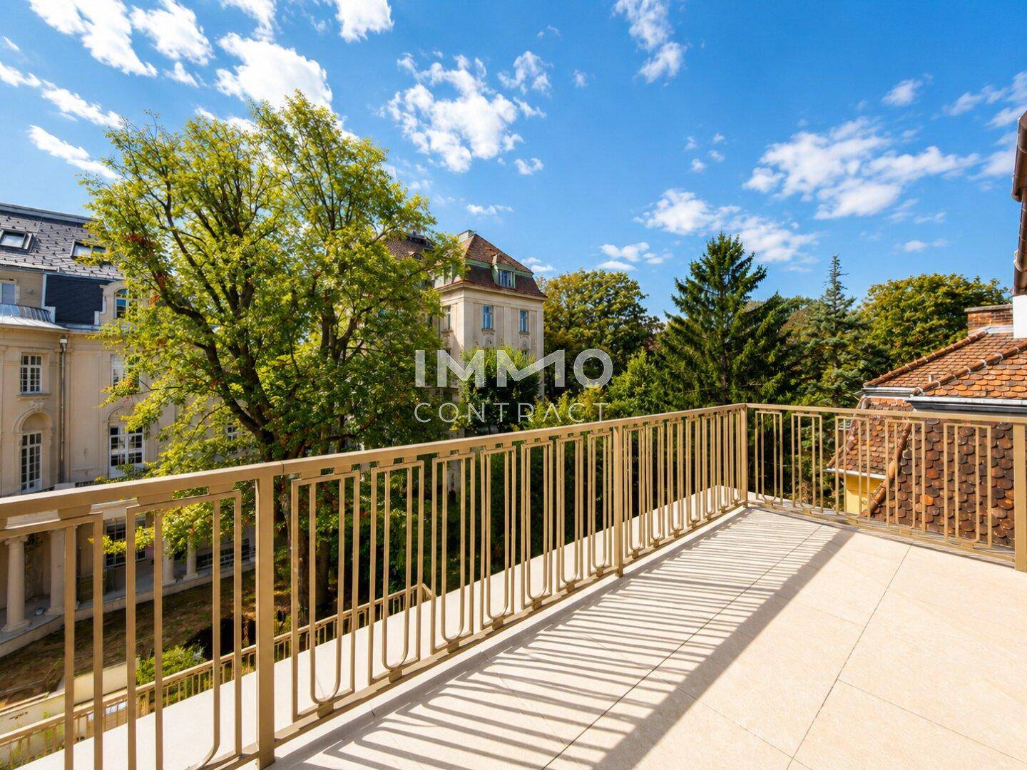 Große Dachterrasse mit Metallgeländer und weitem Blick über die Umgebung und Bäume.