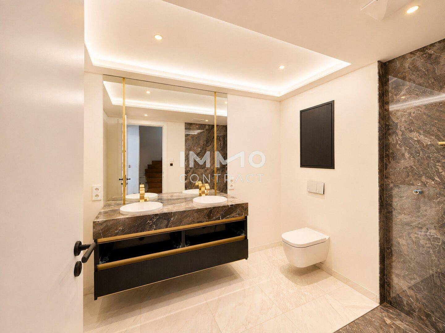 Modernes Badezimmer mit Doppelwaschbecken, Marmorwaschtisch und eleganten Armaturen.