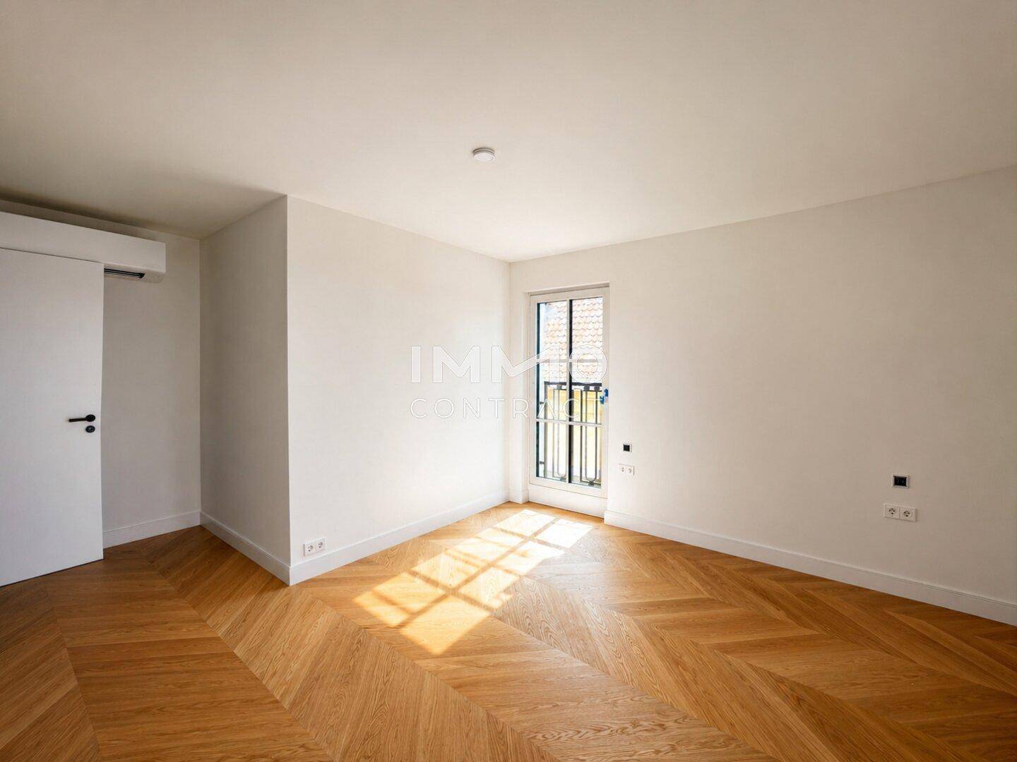 Gemütliches Zimmer mit Fischgrätparkett und einem Fenster mit Blick nach draußen.