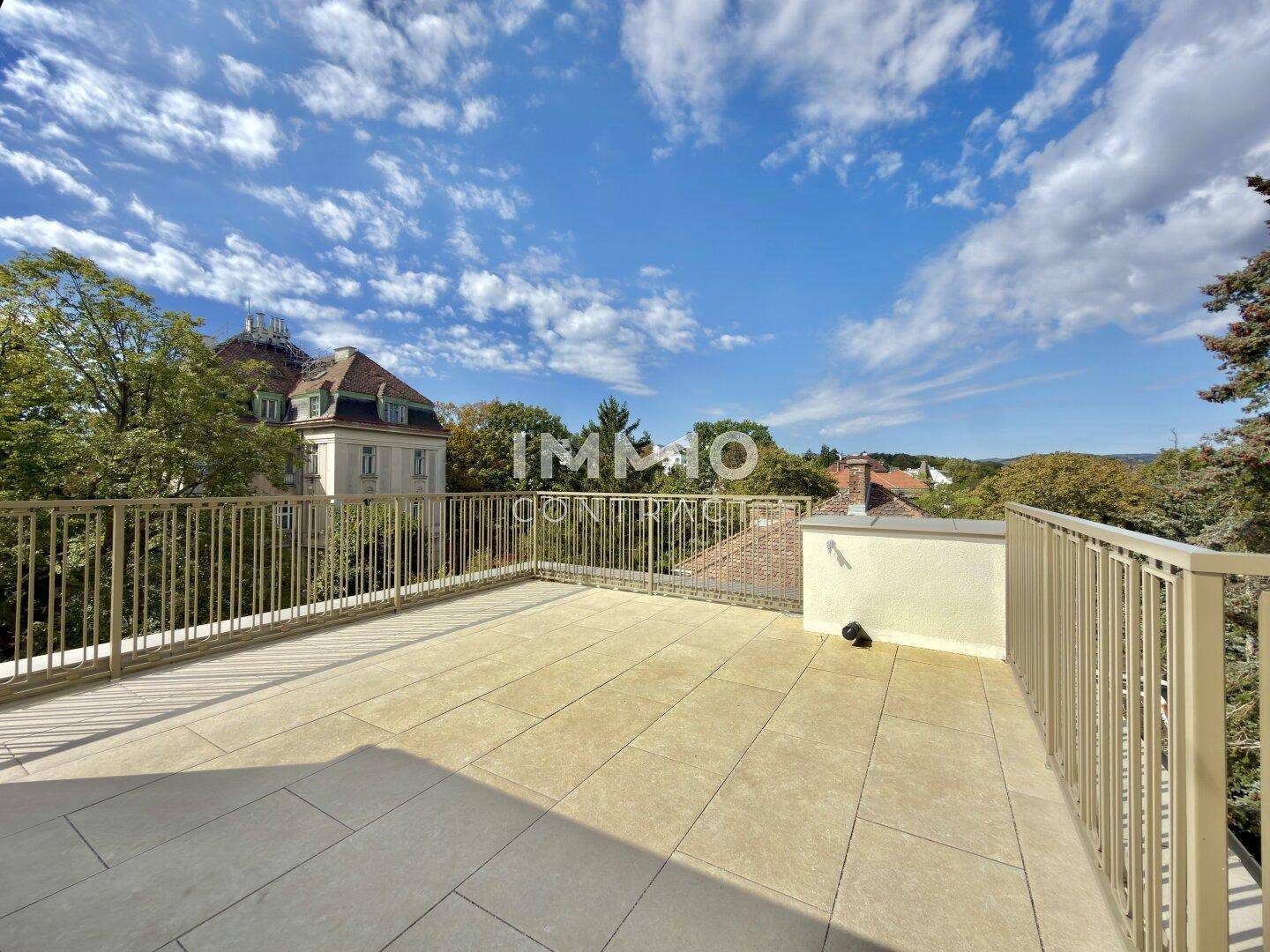 Weitläufige Dachterrasse mit Fliesenboden und Panoramablick auf die umliegende Landschaft.