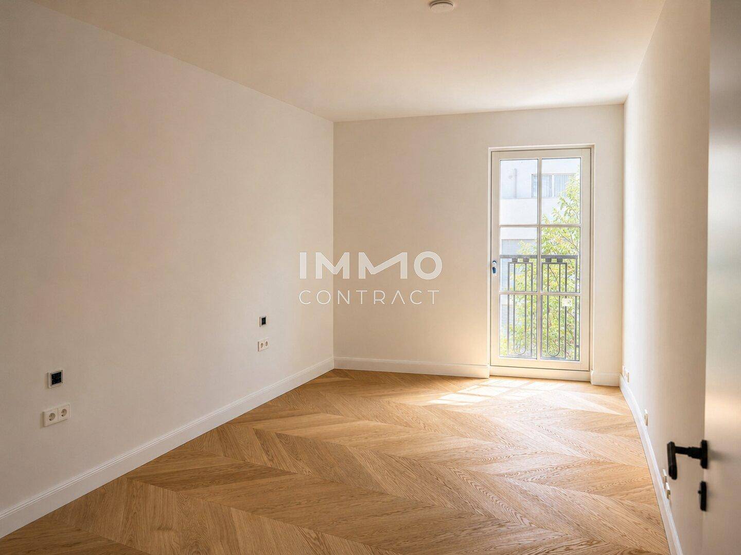 Helles Zimmer mit Fischgrätparkett und Zugang zu einem französischen Balkon, ideal als Schlafzimmer.
