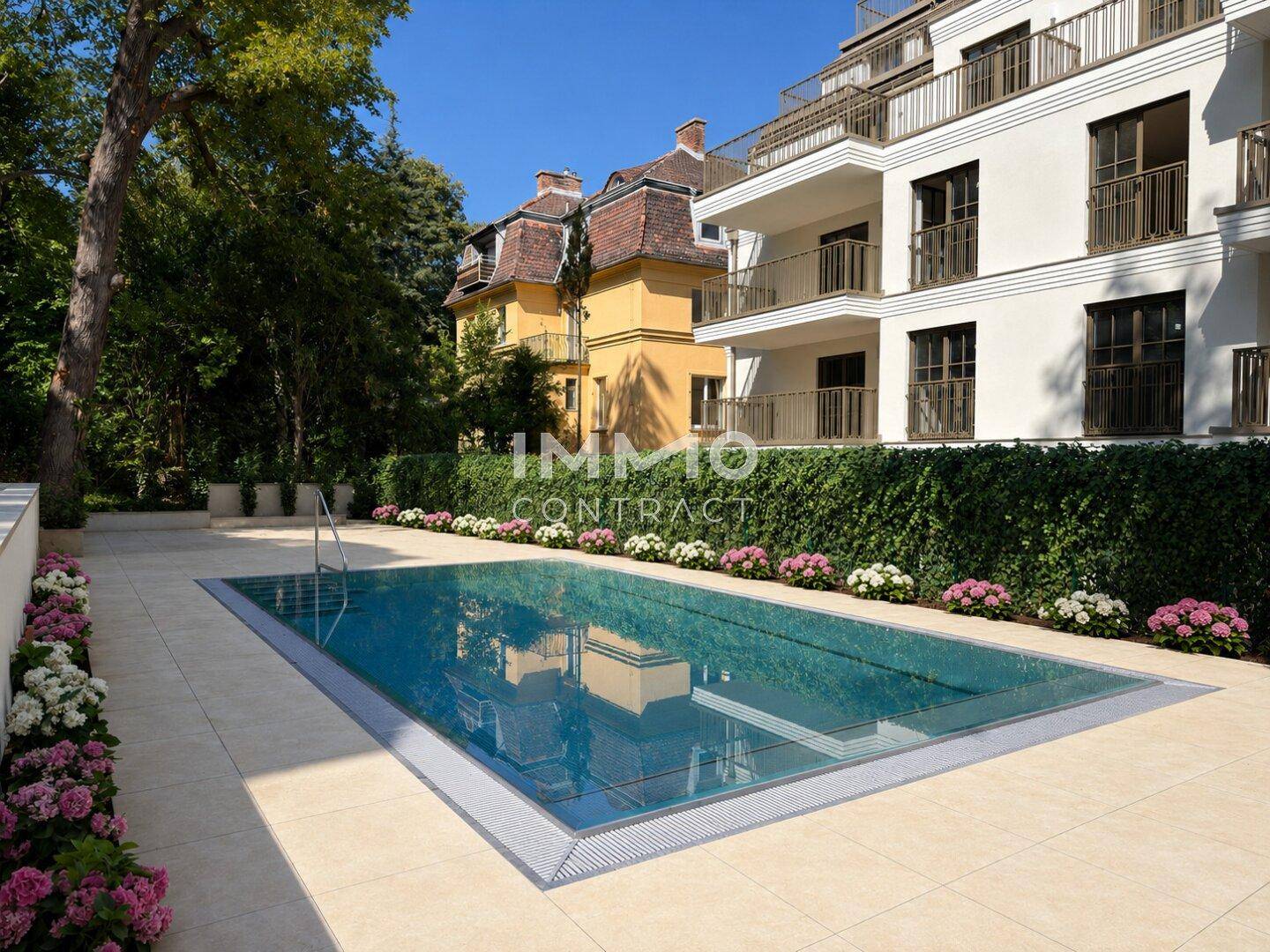Außenpoolbereich mit gepflegter Gartenanlage, Liegestühlen und moderner Architektur im Hintergrund.