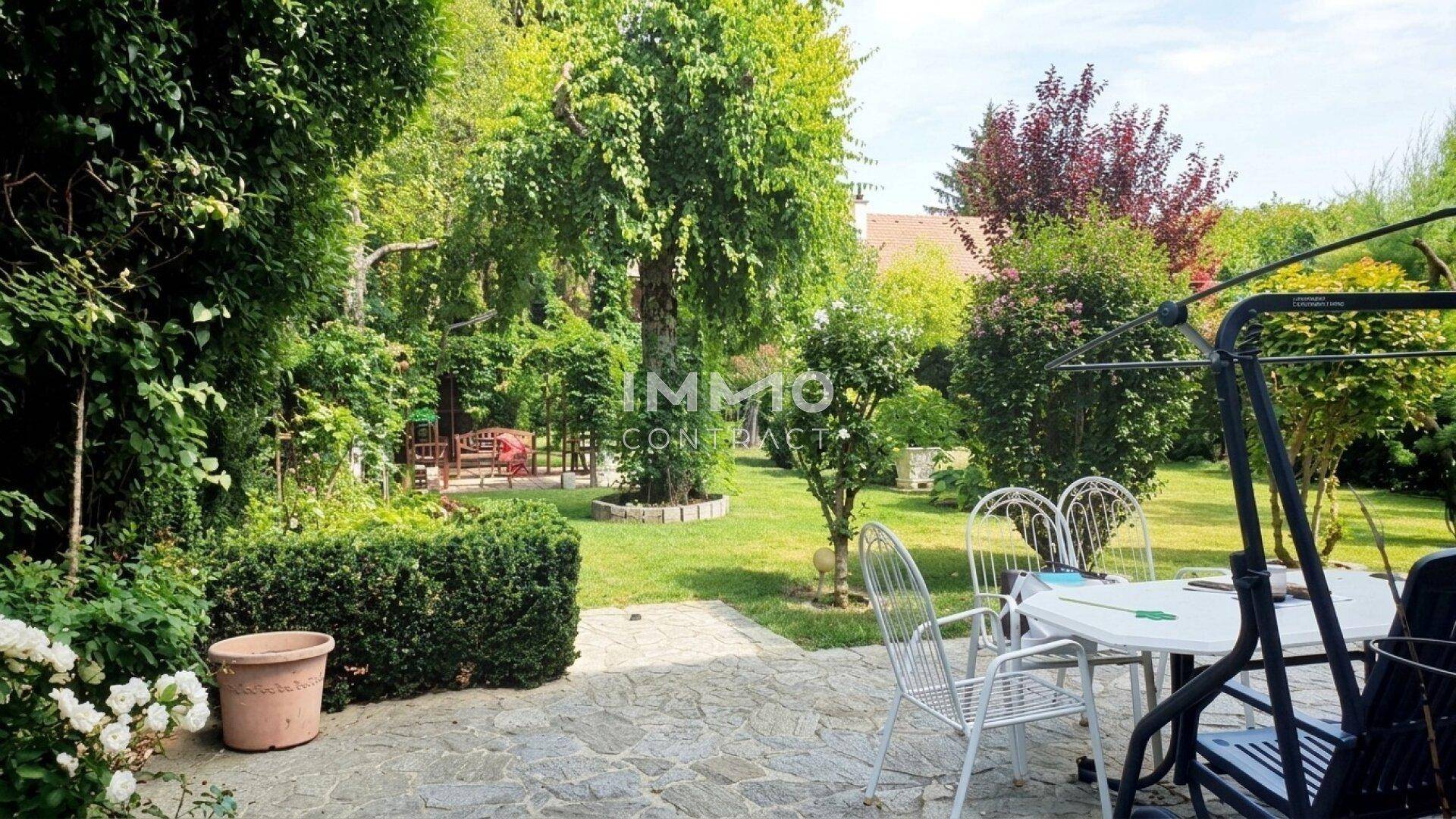 Gepflegter Garten mit gepflasterter Terrasse, Sitzgelegenheiten und üppiger Bepflanzung.