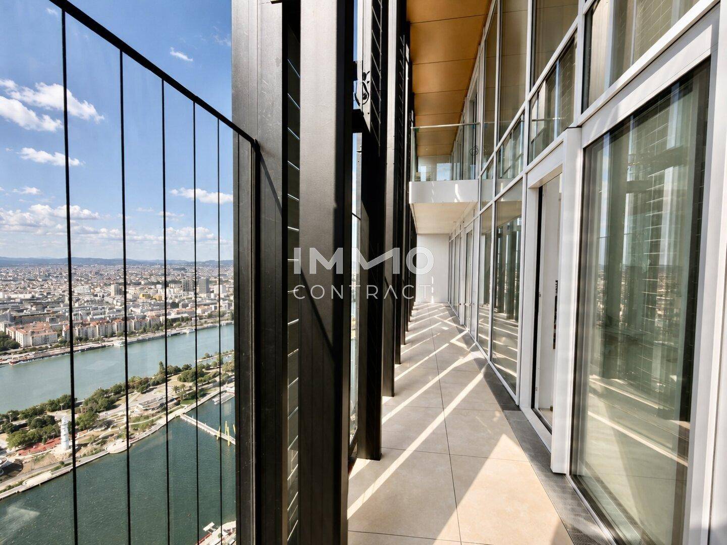 Schmaler Balkon mit Glasgeländer und beeindruckendem Panoramablick auf die Stadt und die Donau.
