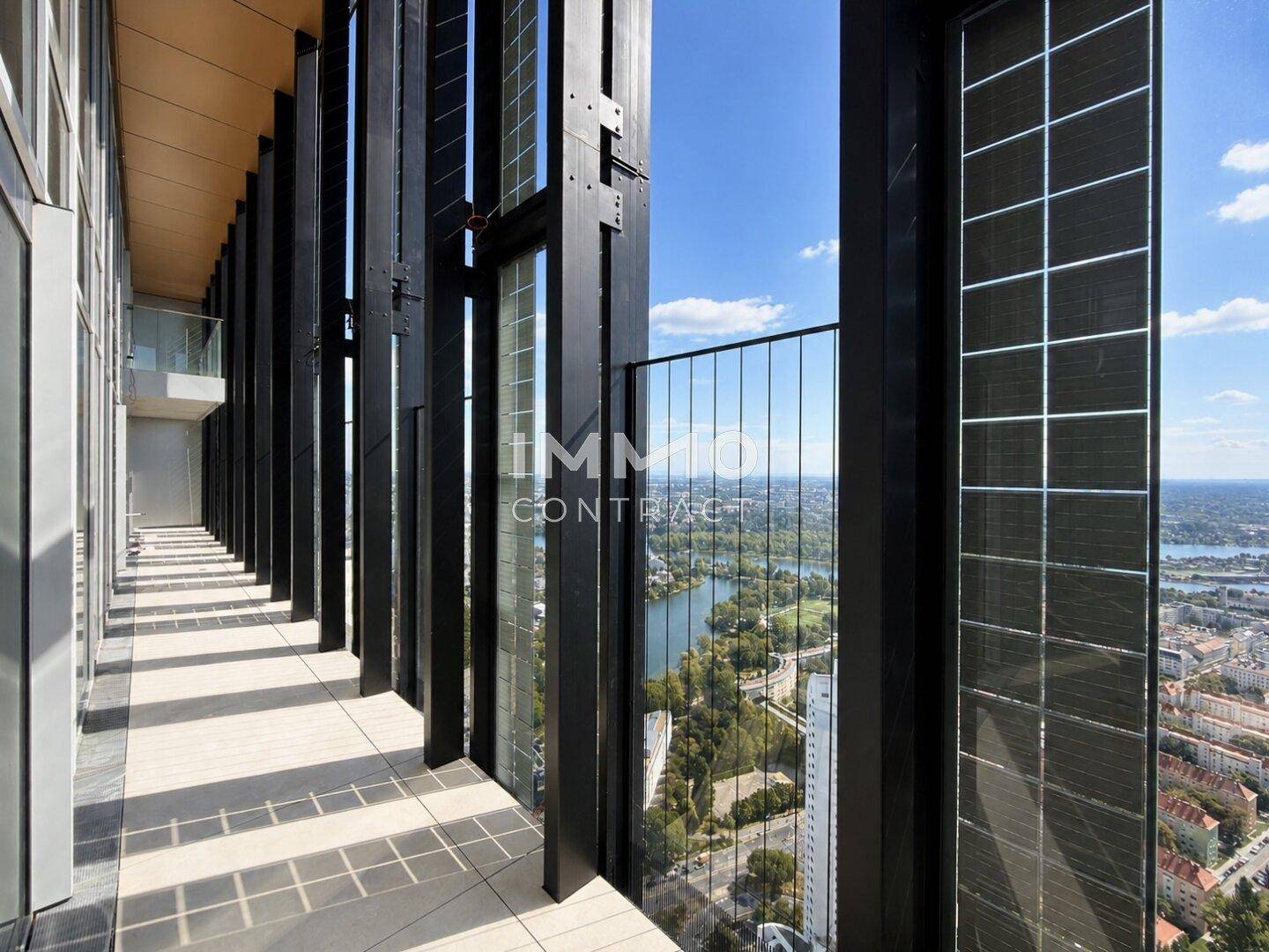 Langer Balkon mit Fliesenboden und weitem Blick über die Stadt und den Fluss.