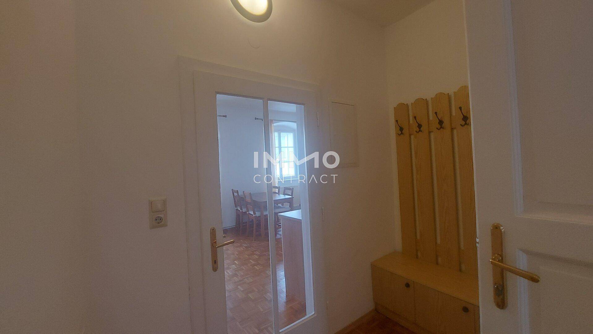 Heller Eingangsbereich mit Garderobe und Holzboden.
