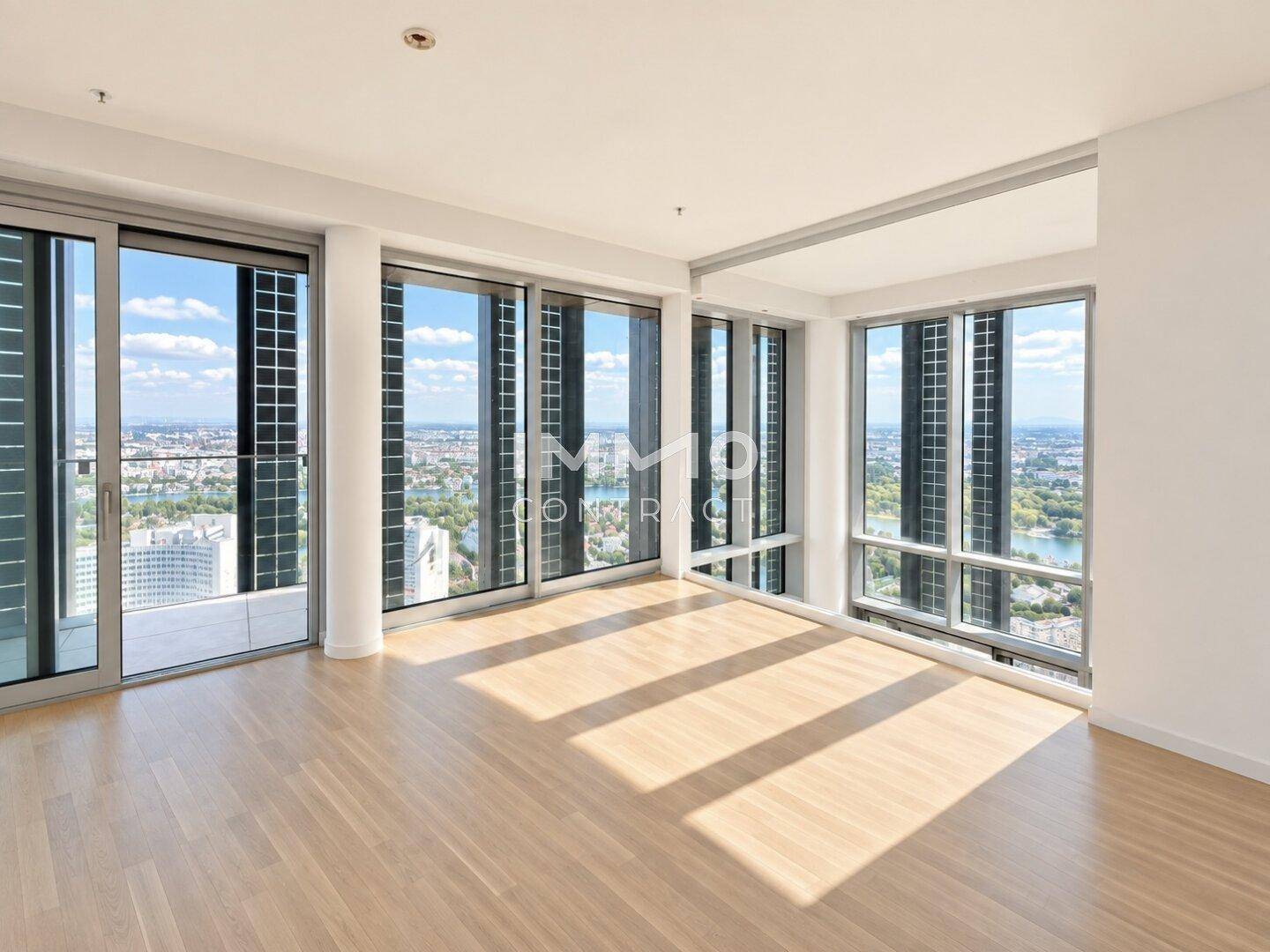 Heller Eckraum mit großen Fenstern auf zwei Seiten und weitem Blick über Stadt und See.