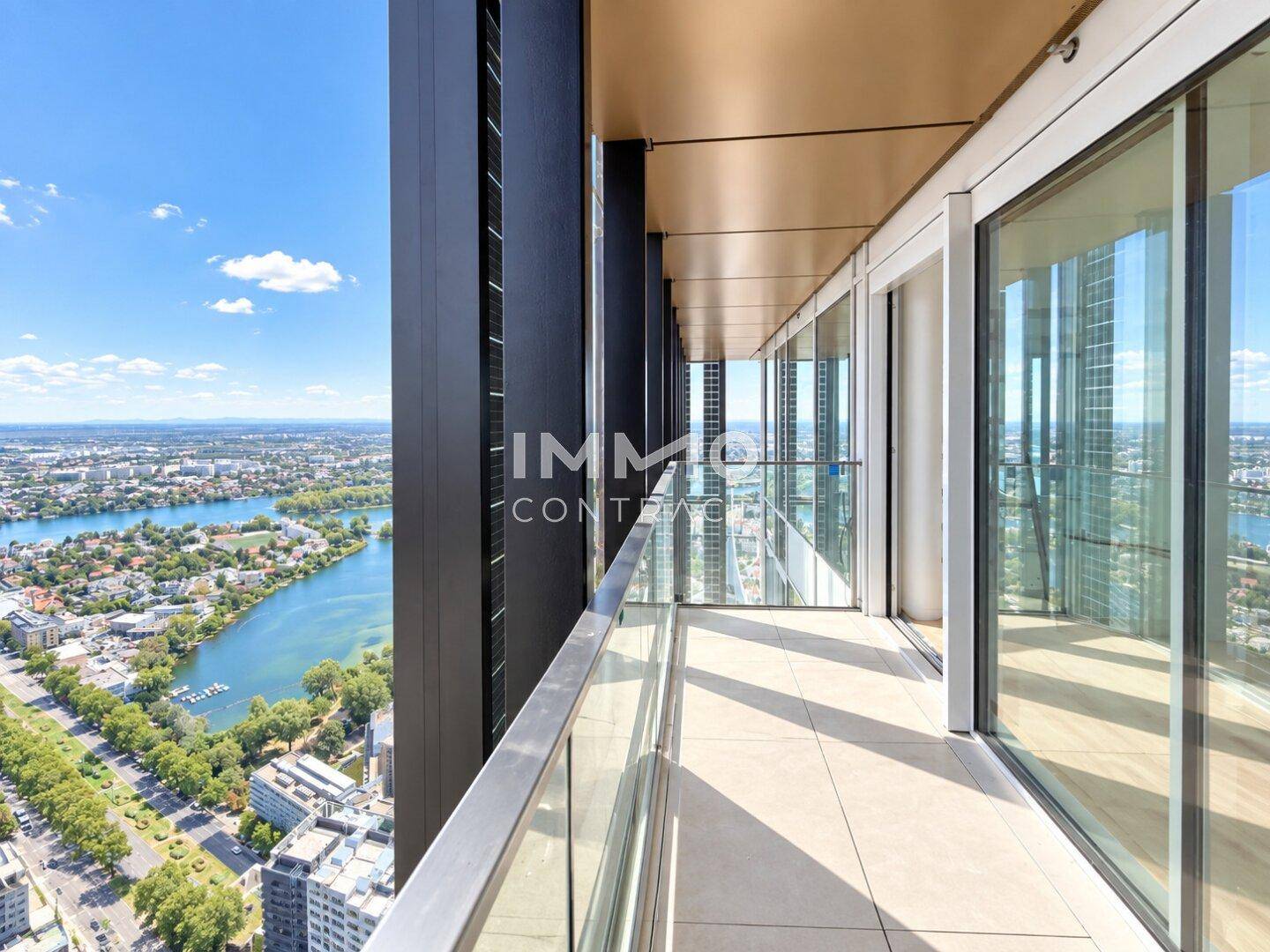 Langer Balkon mit Glasgeländer und beeindruckendem Panoramablick auf die Stadt und den Fluss.