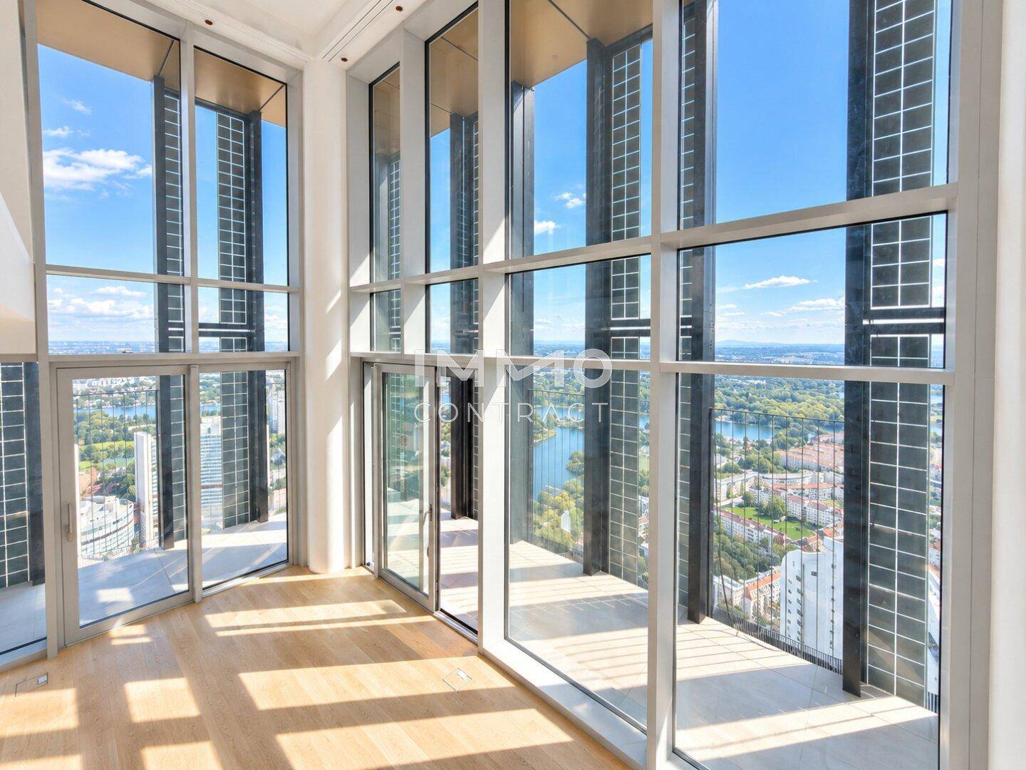 Lichtdurchfluteter Raum mit Panoramafenstern, die einen weiten Blick über die Stadt und den See bieten.