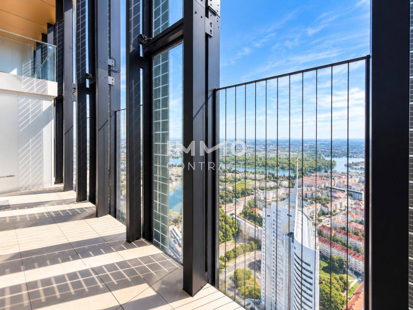 Moderner Balkon mit Metallgeländer und weitem Blick über die Stadt und den Fluss.