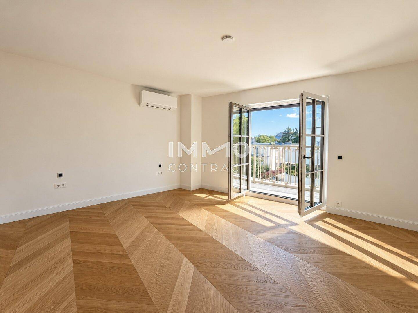 Großes Schlafzimmer mit Fischgrätparkett, Klimaanlage und Zugang zu einem sonnigen Balkon.