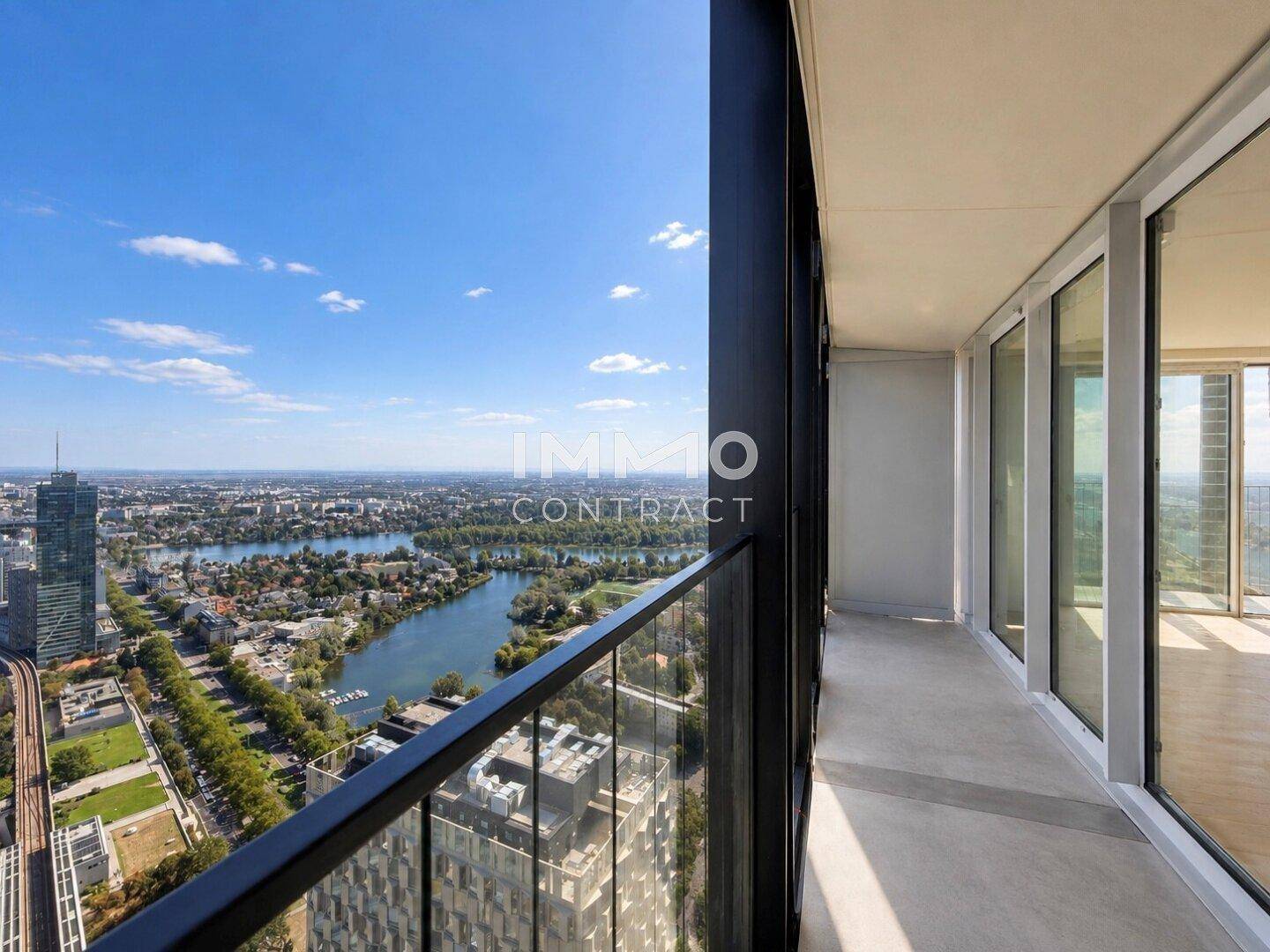 Geräumiger Balkon mit moderner Verglasung und weitem Blick auf die Stadt und das Wasser.