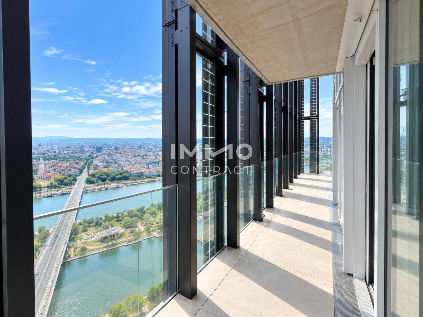 Langer Balkon mit Glasgeländer und atemberaubendem Blick auf die Stadt und die Donau.