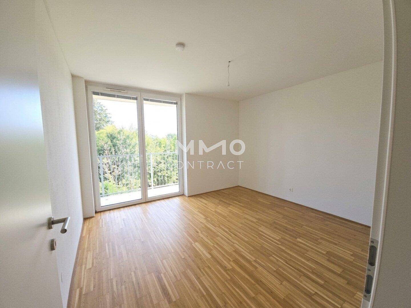 Helles, leeres Zimmer mit Parkettboden und Zugang zu einem Balkon, bereit zur individuellen Gestaltung.