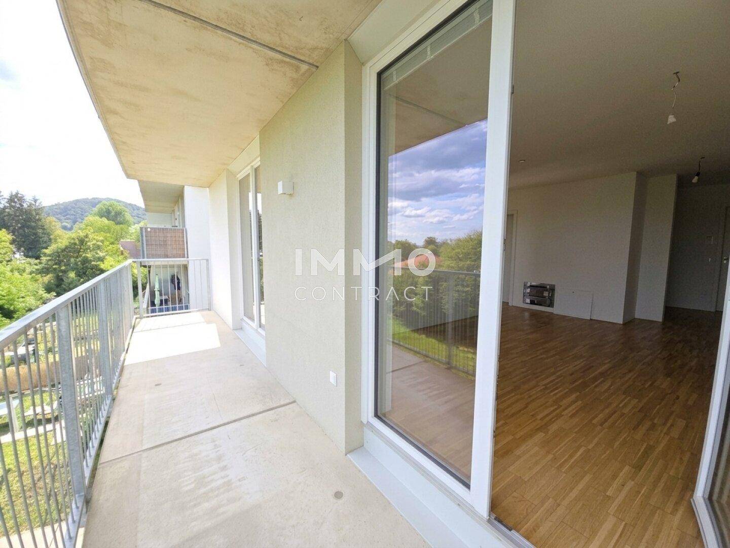 Geräumiger Balkon mit Metallgeländer und Blick ins Grüne, direkt zugänglich vom Wohnbereich.