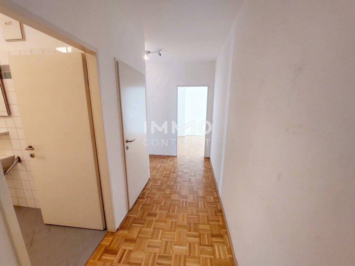 Heller Flur mit Parkettboden und Zugang zu verschiedenen Räumen der Wohnung.
