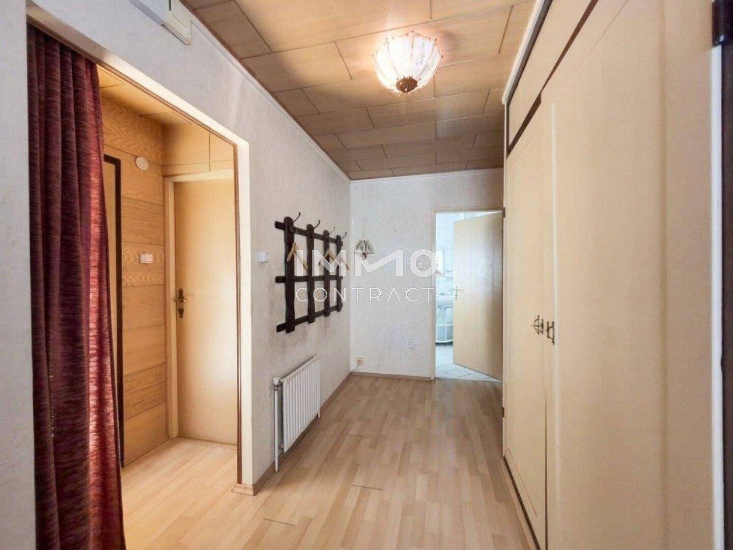 Heller Flur mit Laminatboden, Einbauschränken und Zugang zu weiteren Räumen.