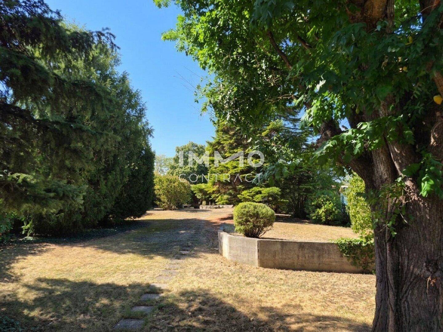 Großer, gepflegter Gartenbereich mit Rasenflächen und verschiedenen Bäumen und Sträuchern.